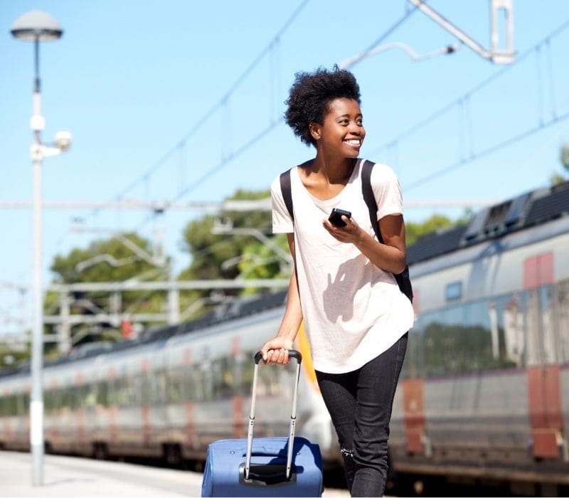 Woman carrying her luggage and holding her phone. 